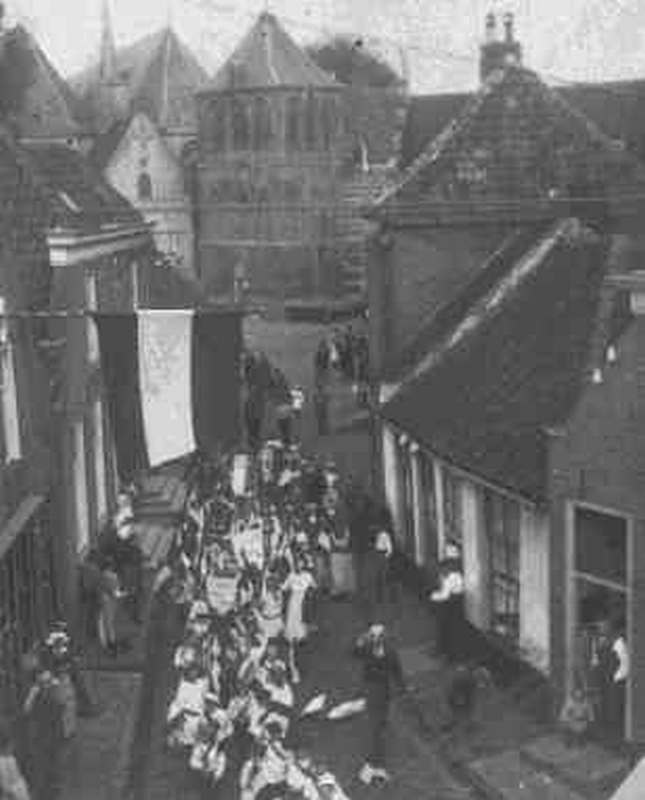 Optocht tijdens het volksfeest 1921 in Vollenhove. De stoet komt hier vanaf het Kerkplein richting Bentstraat.